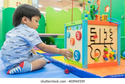 Asian Kid Baby Playing With Colorful Educational Toy In Playground. Little Boy Is Learning Number From Educator Counting Toy. For Pre School And Young Children Play And Learn Concept.