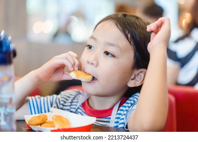 Asian Kid Boy Eating Chicken Nugget In Restaurant. Fastfood Fried Chicken.delicious Face.5 Years Old Kid Asian Boy Eat Fried Nugget Chicken Snack.kids Menu In Restauratn.hand Holding Nugget.food Child