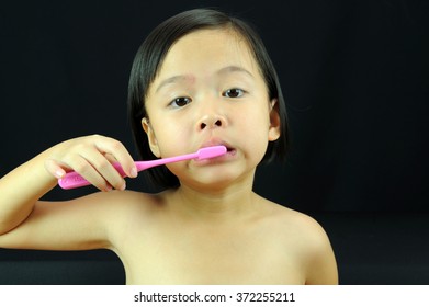 Asian Kid Brushing The Teeth.