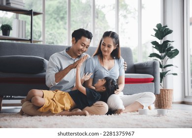 Asian kid cute girl lying on mom and dad happy living relaxing with young mom and dad at home, Happy young family living concept - Shutterstock ID 2281375967