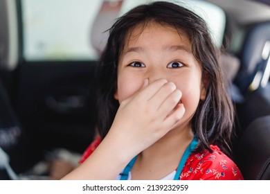 Asian Kid Girl Covers Her Nose Because Of Her Sibling Farting Make A Bad Smell On The Car, Travel With Fart.Digestive Diarrhea.Kid Runny Nose And Sick.Kid Girl Suffering From Bloating And Flatulence.