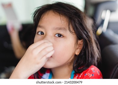 Asian Kid Girl Covers Her Nose Because Of Her Sibling Farting Make A Bad Smell On The Car, Travel With Fart.Digestive Diarrhea.Kid Runny Nose And Sick.Kid Girl Suffering From Bloating And Flatulence.