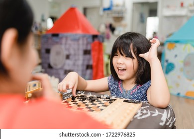 Asian Kid Girl And Mother Stay At Home Lockdown From Covid-19 Coronavirus Crisis Are Playing Chess While Spending Time Together At Home.Smart Kid Home School Kid With Mom.Stay Home Stay Safe With Mom.