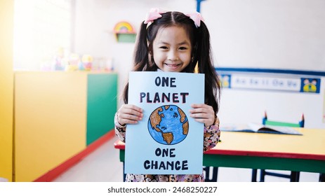 Asian kid holding climate change banner with class room school on background. Child student celebrating earth day - Powered by Shutterstock