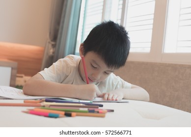 An Asian Kid Painting Color In Paper