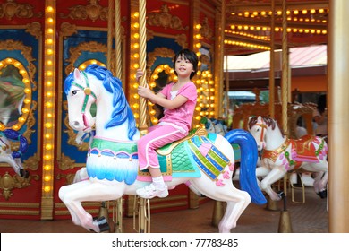 Asian Kid Playing In Merry Go Round