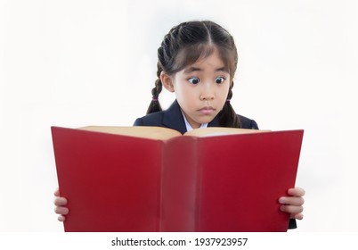 asian kid shocking action when reading vintage textbook on white isolated background to know about historical record or magic in pass(include path)