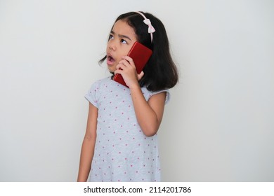 Asian Kid Showing Confused Expression When Answering A Phone Call