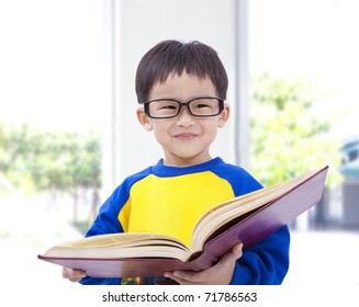 Asian Kid Smiling And Holding Book