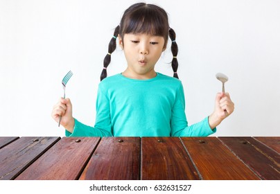 Asian Kid With Spoon And Fork.