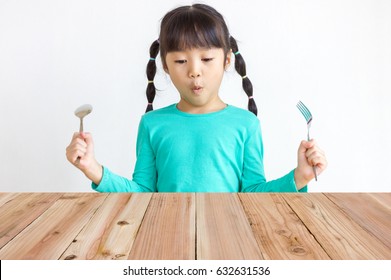 Asian Kid With Spoon And Fork.