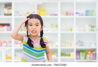 Asian kid is stressed, drug shelf in the pharmacy is the background.