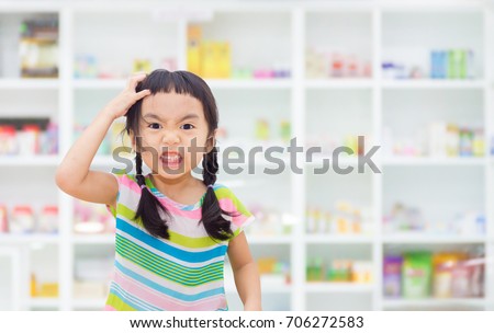 Asian kid is stressed, drug shelf in the pharmacy is the background.