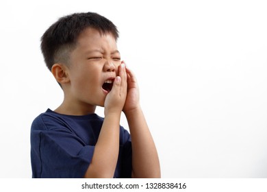 Asian Kid Suffering From Toothache Pain, Holding His Cheek, Isolated On White Background. Dental Health And Care Concept.