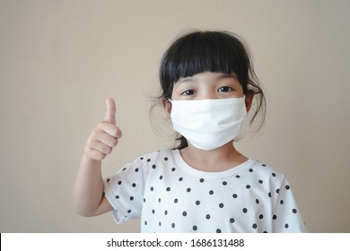 Asian Kid Use Medical Mask Or Surgical Mask To Protect Her From Virus, Sickness, Covit-19 And Coronavirus Infection.