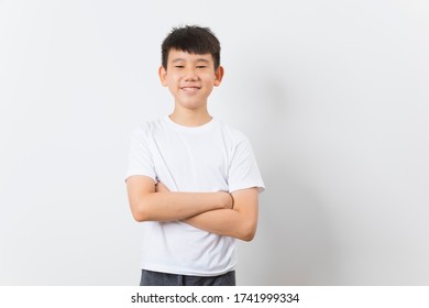 Asiatisches Kind in weißem T-Shirt lächelt auf weißem Hintergrund.
