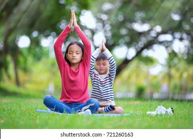 Asian Kids Doing Yoga Pose In The Park Outdoor