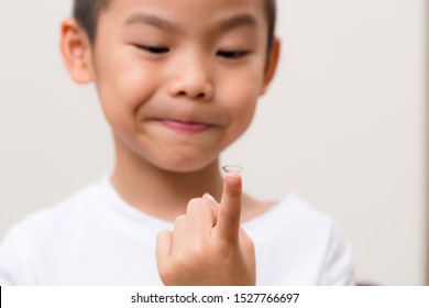 Asian Kids Hold With A Contact Lens