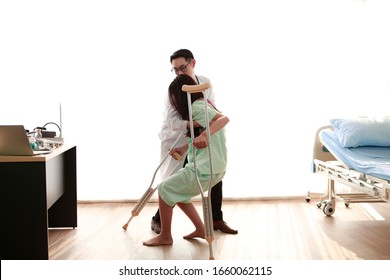 Asian Kindly Man Doctor With Glasses  Helping Women Patient With Long Black Hair Who Injury Legs After Falling On Wooden Floor In Hospital. Bangkok Thailand South Asia