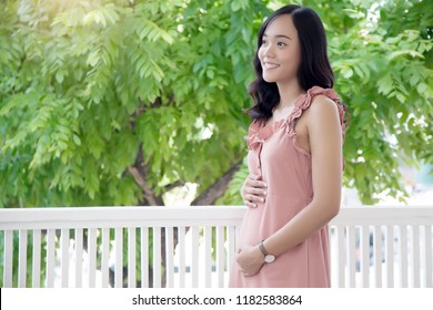 Asian Lady Carry Pregnancy New Baby At Balcony . First Time Baby Concept.