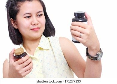 Asian Lady Checking A Bottle Of A Dietary Supplement.