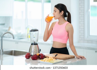 Asian lady drink a mixed fruit for healthy in a kitvhen room - Powered by Shutterstock