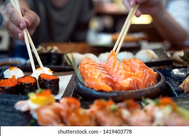 Asian lady eat a Salmon fish sashimi and Sushi in Japanese restaurant for good healthy, Tokyo, Japan. This image can use for food, and Japanese food concept