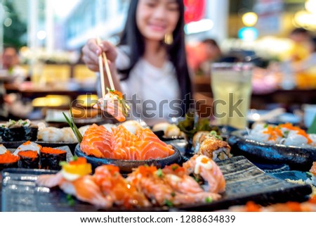 Asian lady eat a Salmon fish sashimi and Sushi in Japanese restaurant for good healthy, Tokyo, Japan. This image can use for  food, and Japanese food concept