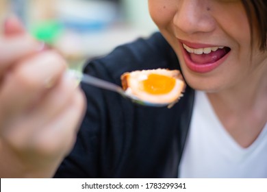 Asian Lady Eating Boiled Egg  By Spoon