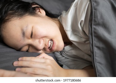 Asian Lady Girl Suffering From Bruxism While Lying In Bed At Night,female Grinding Of The Teeth During Sleep,teeth Clenching,sleep Disorders,oral Health Problems,dental Care,sleep Bruxism Concept