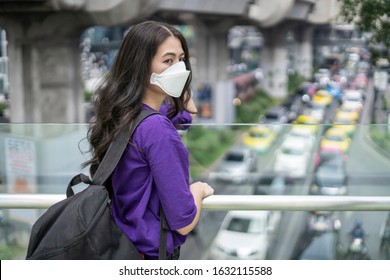 The Asian lady in purple t-shirt always wears mask to prevent the Wuhan coronavirus outbreak when she is outdoor or in the public