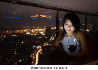 Asian Lady Read Message On Mobiel At Luxury Restaurant In The Night, Bangkok, Asia