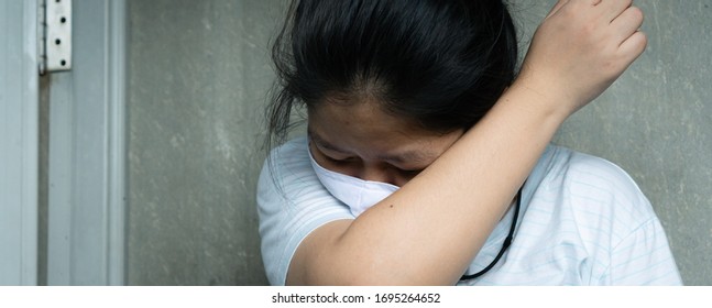 Asian Lady Sneezing On A Handmade Mask. Cover With Inner Elbow. Way To Protect From Disease. COVID-19. Coronavirus. Healthcare Of Sickness People.