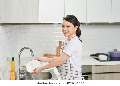 Asian lady wash a dish in kitchen room
