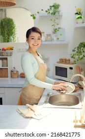 Asian lady wash a dish in kitchen room