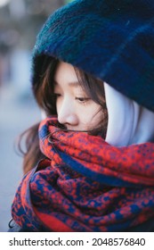 An Asian Lady Wearing A Red Scarf In A Cold Winter.