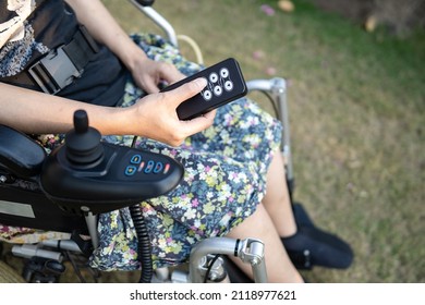 Asian lady woman patient on electric wheelchair with joystick and remote control at nursing hospital ward, healthy strong medical concept