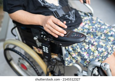 Asian lady woman patient on electric wheelchair with joystick at nursing hospital ward, healthy strong medical concept