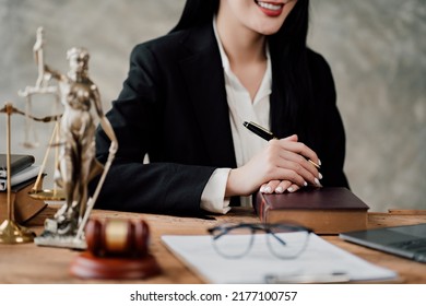 Asian lawyer woman working with a laptop computer in a law office. Legal and legal service concept. Looking at camera