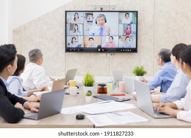 Asian Leader Old Man Lead Group Of Business Team Using Web Conferencing Technology In Office For Video Call With Colleagues