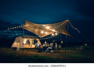 Asian LGBTQ+ couple drinking and barbecue in a romantic camping setting. Groups of friends and couples having a drink party in a camping atmosphere amidst forests and rivers. - Powered by Shutterstock