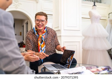 Asian LGBTQ Guy Bridal Shop Owner Using Laptop Help Male And Female Couple Customer Choosing Wedding Gown And Suit At Wedding Studio. Small Business Entrepreneur Wedding Planner And Marriage Concept