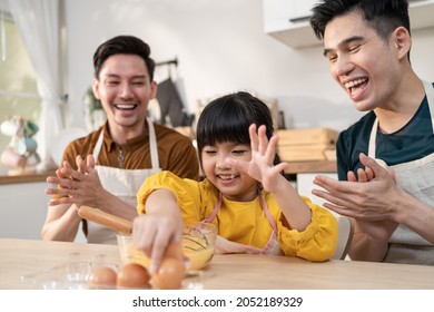 Asian LGBTQ Male Gay Family Teach Girl Kid Stirring Eggs In Kitchen. Attractive Handsome Man Couple Take Care And Spend Time With Little Adorable Child Bake Bakery, Enjoy Parenting Activity At Home.