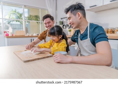 Asian LGBTQ Man Gay Family Make Bake With Girl Kid In Kitchen Together. Attractive Handsome Male Couple Spending Time With Little Cute Child Baking Bakery Together, Enjoying Parenting Activity At Home