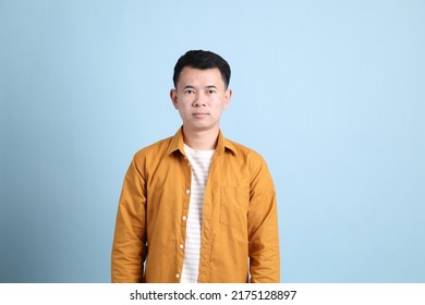 The Asian LGBTQ Man With Yellow Shirt Standing On The Blue Background.