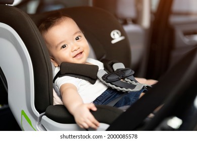 Asian Little Baby Happy And Fun While Fastened Belt And Seat In The Safety Car Seat. A Boy Looking Outside And Smile In A Car. 