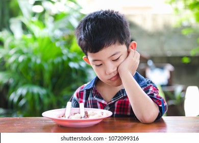 Asian Little Boy Boring Eating With Rice Food On The Wooden Table, Kid Without A Feeling Of Appetite