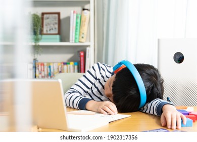 An Asian Little Boy Get Tired And Bored From Online Study At Home, He Lied Down His Lied On The Desk And Have A Nap. Kids Health, Covid 19 Pandemic, PM2.5, Air Pollution, New Normal Lifestyle, Urban.