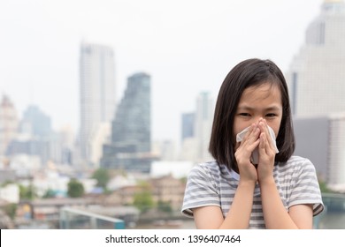 Asian Little Child Girl Blowing Nose In Paper Handkerchief, Sick People Sneezing In A Tissue In The City, Concept Of Pollution,dust Allergies,polluted Air,health Care,bad Smell,Covid-19, SARS-CoV-2