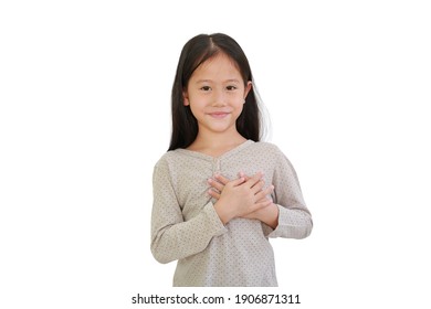 Asian little child girl holding hands on chest isolated on white background. Kid place arms on heart gesture of love.